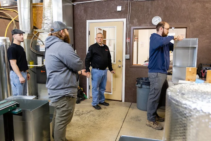 Morris Heating & Cooling technicians in the shop discussing ductwork